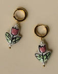 Pair of earrings with tulip design on a beige background