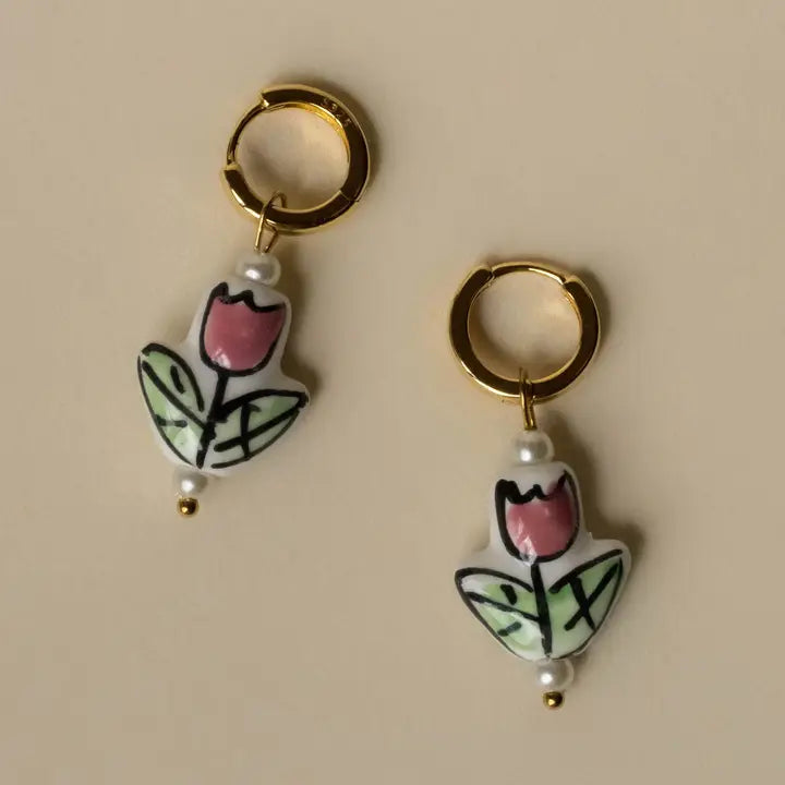 Pair of earrings with tulip design on a beige background