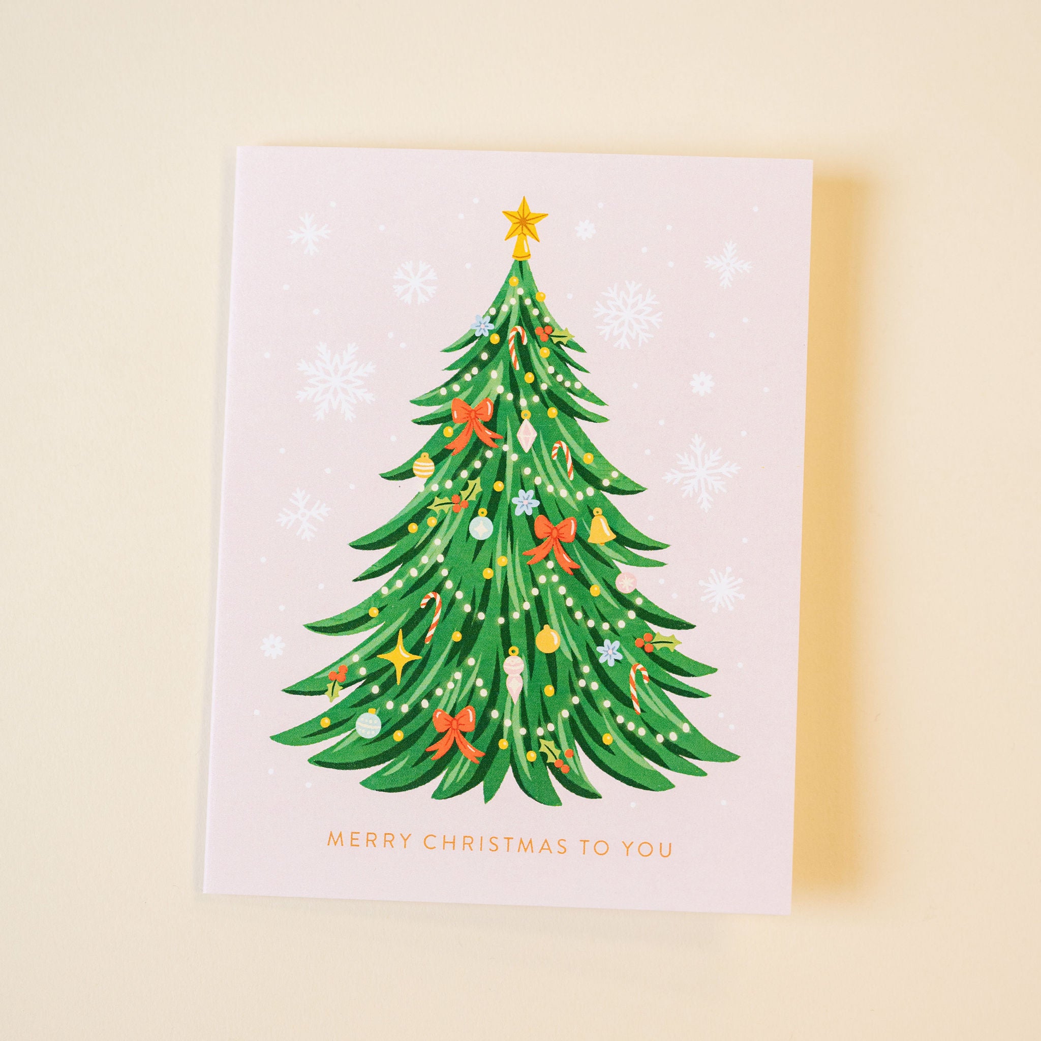 Christmas card with a decorated Christmas tree on a beige background